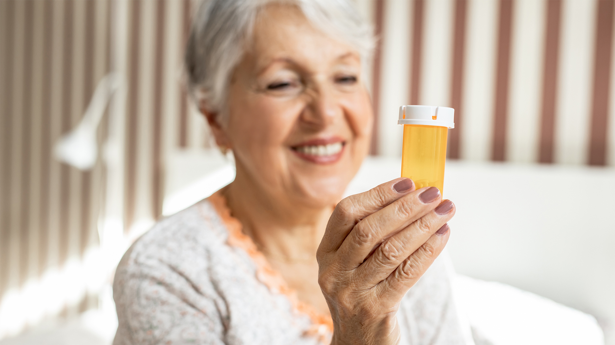  Senior woman holding a prescription bottle.