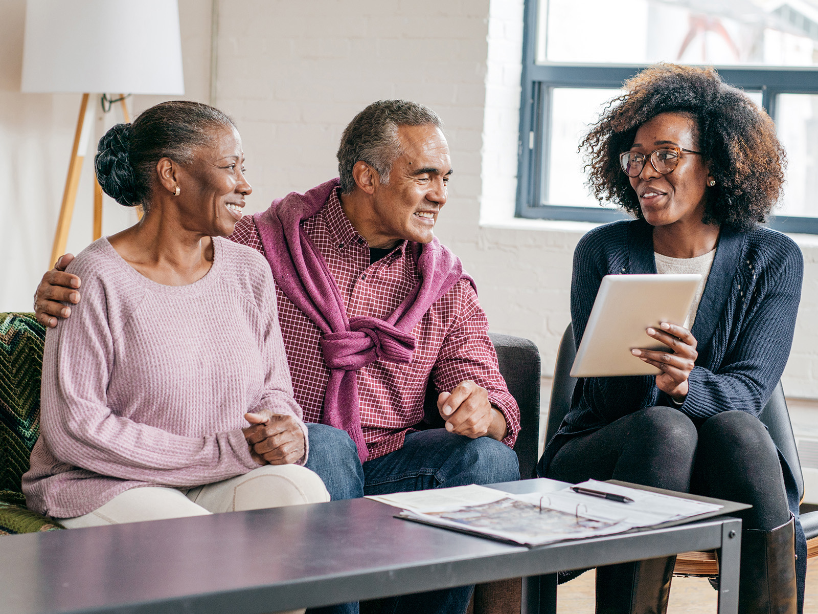 Senior couple reviewing health plan options with a friendly sales agent.