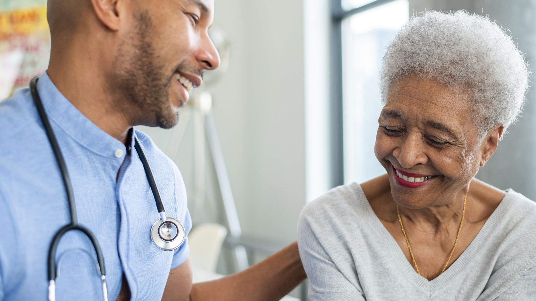 Male doctor and senior woman smiling.