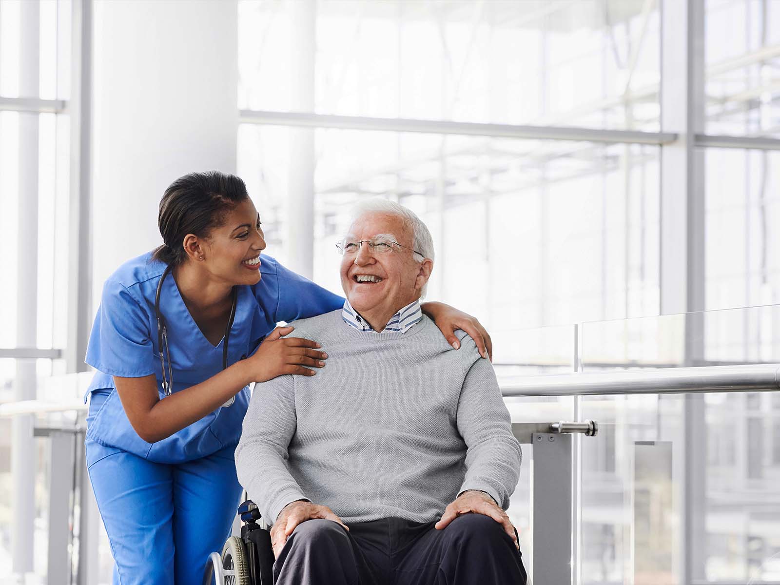 Senior man and healthcare professional smiling.