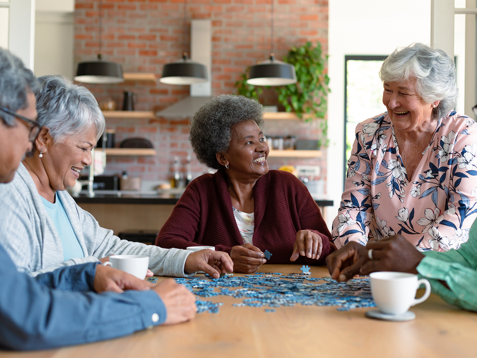 Group of seniors solving a puzzle together at table.