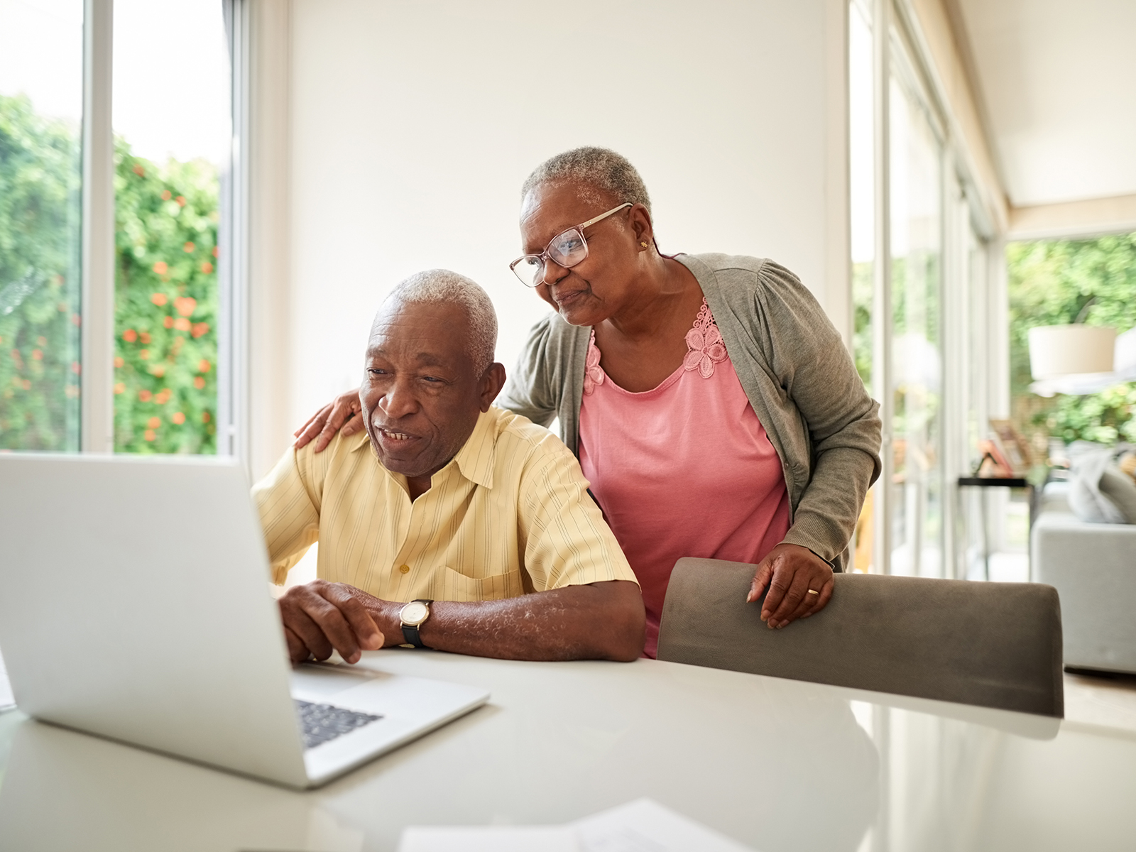 Senior couple at home looking at laptop.