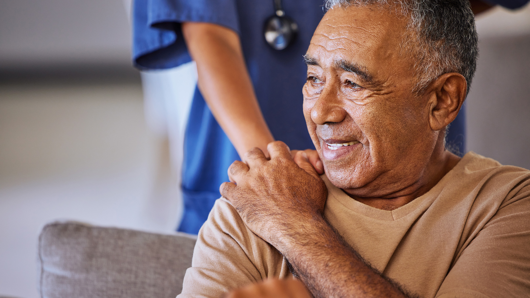 Senior man being comforted by a medical professional.