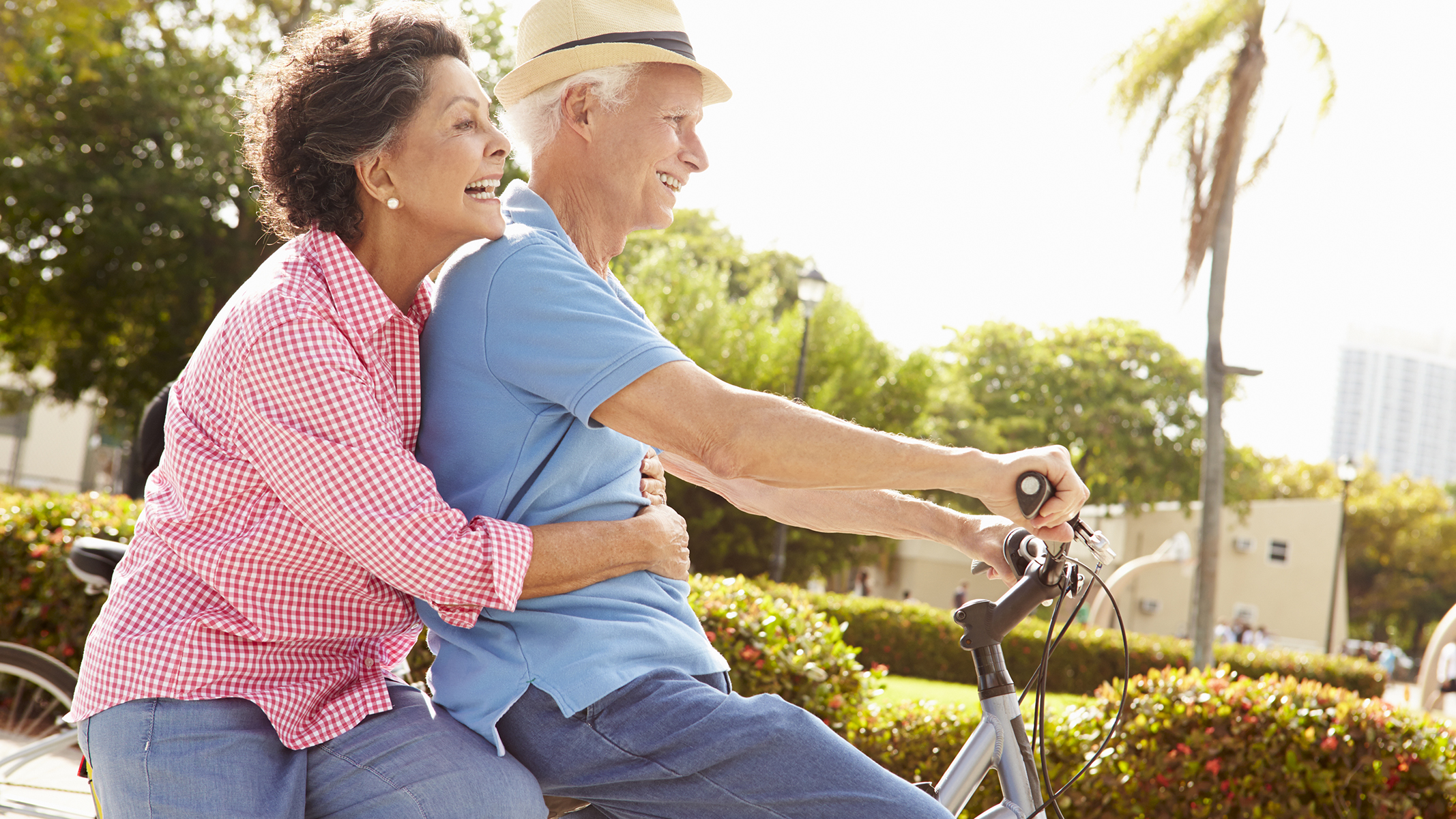 Senior couple riding on tandem bike through the neighborhood.