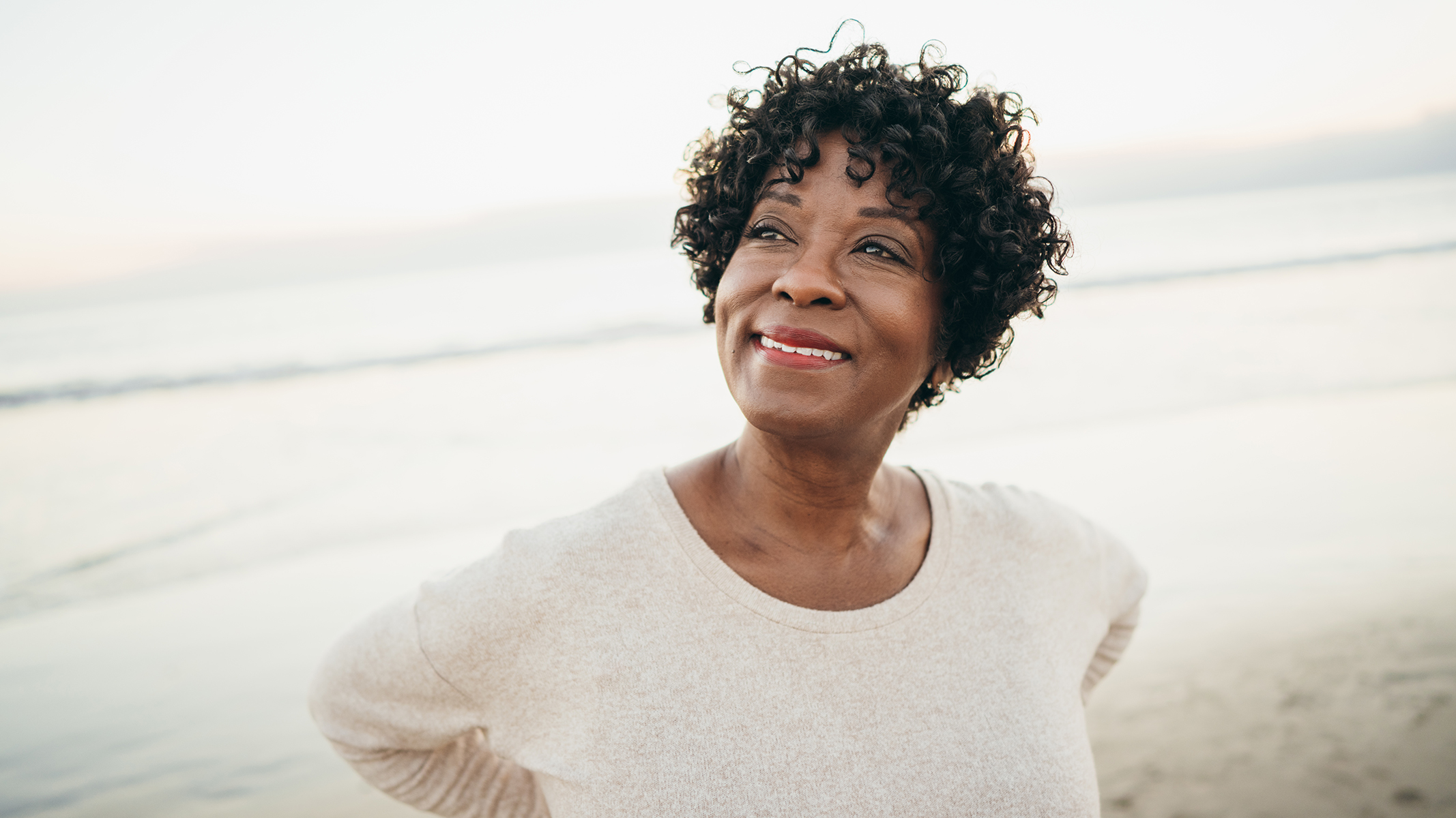 Woman smiling at the beach.