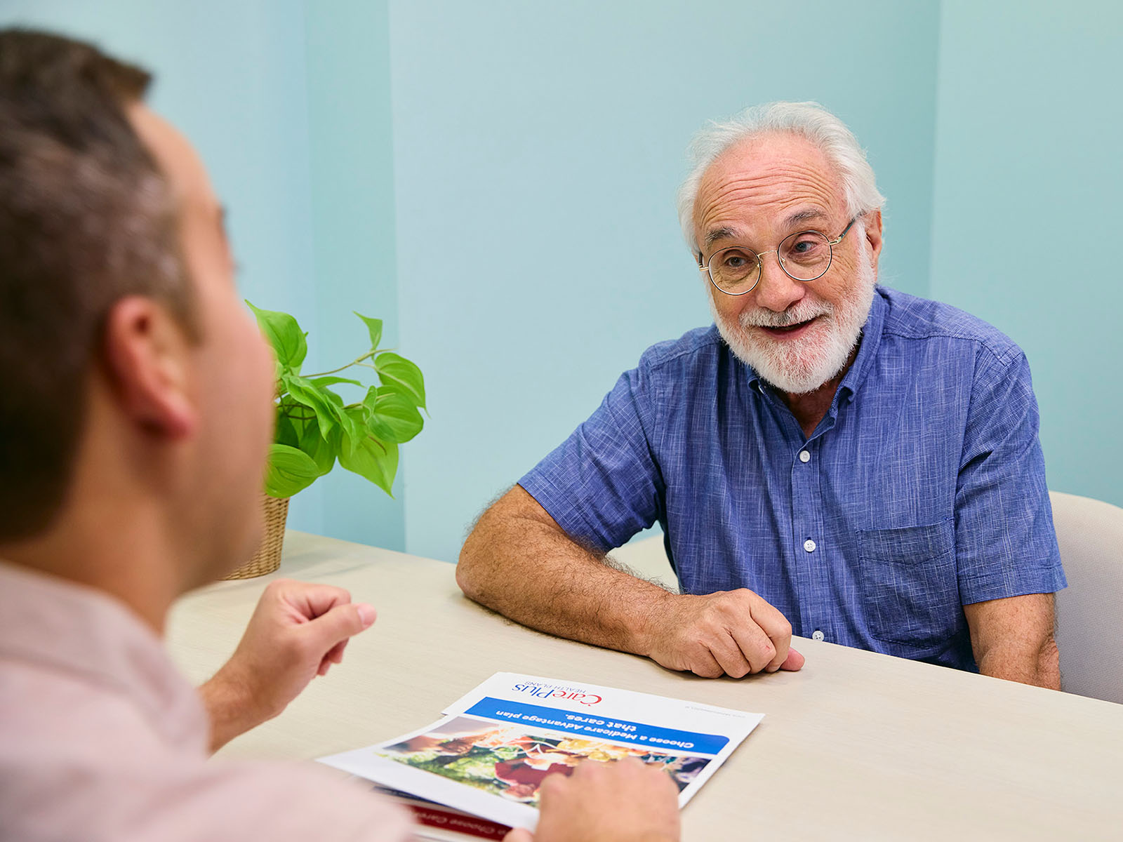  Senior man speaking with CarePlus sales agent.