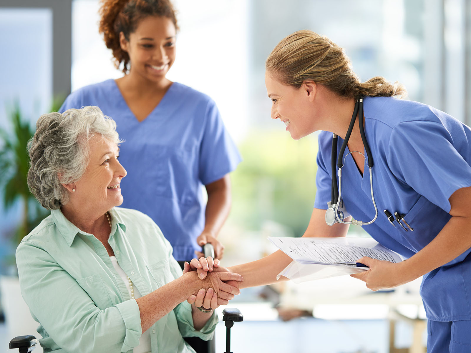  Senior woman greeting healthcare professionals.